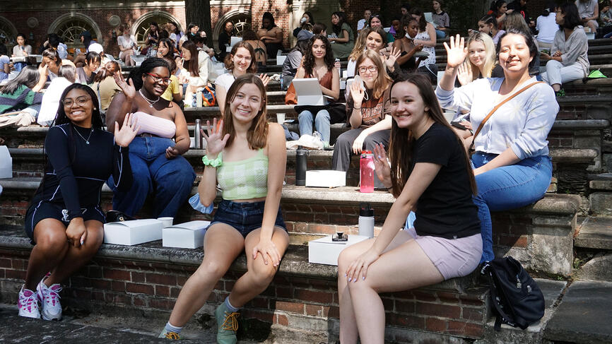 students smiling and waving at camera