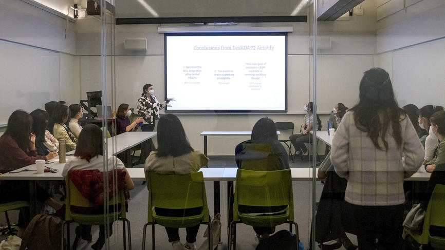 Students present their biochemistry work to a packed room.