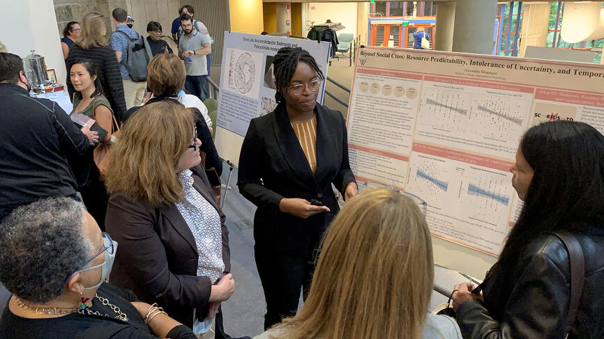 A Wellesley student presents her poster session to a crowd during the science complex celebration.