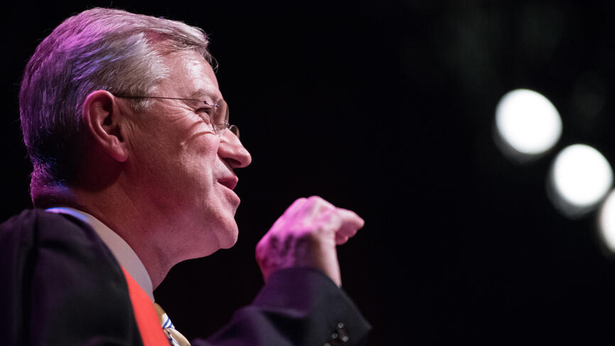 Provost Andrew Shennan speaks at the podium in Alumnae Auditorium. 