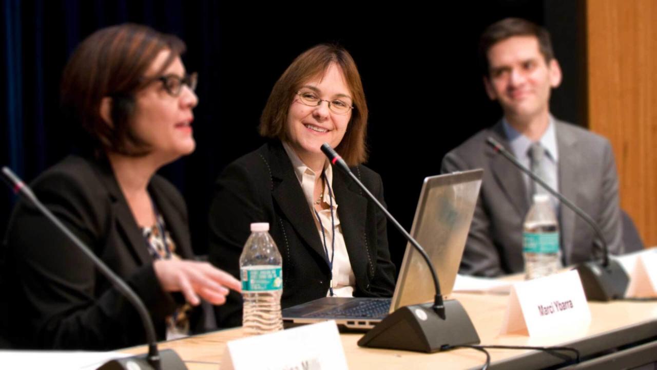 Sari Kerr sits at a panel presentation.