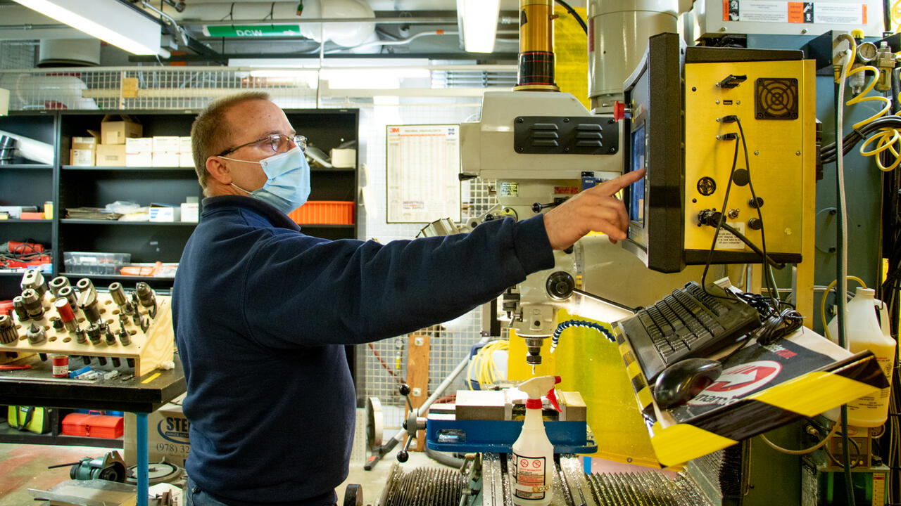 A photo of Larry Knowles working in the machine shop on campus.