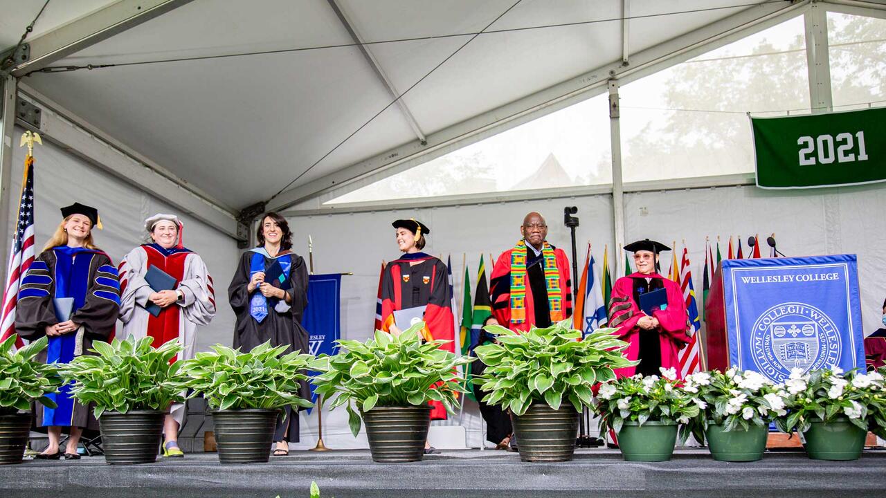 faculty standing on the commencment stage