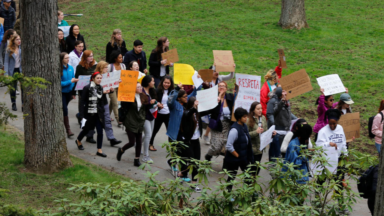A group of students march outside of Green Hall on May 1, 2017 with signs supporting Immigrant rights