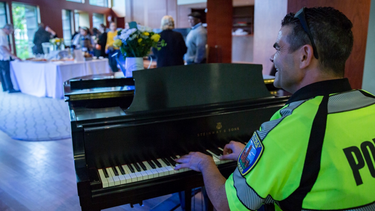 A Wellesley Police Officer plays a piano.