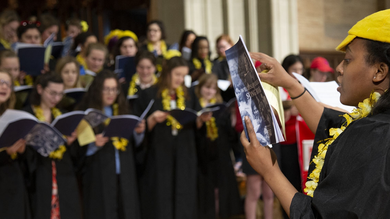 Students dressed in yellow sing inside the chapel