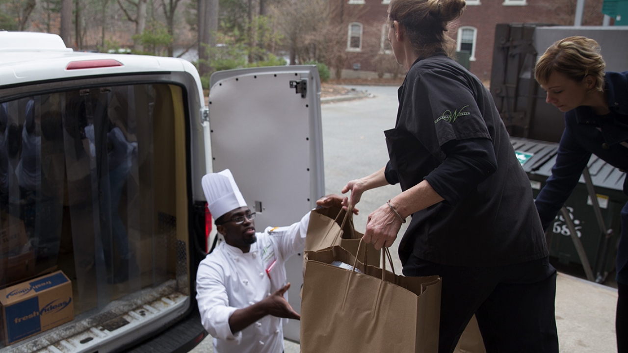 Volunteers load food into the back of a truck from a Wellesley dining hall. 