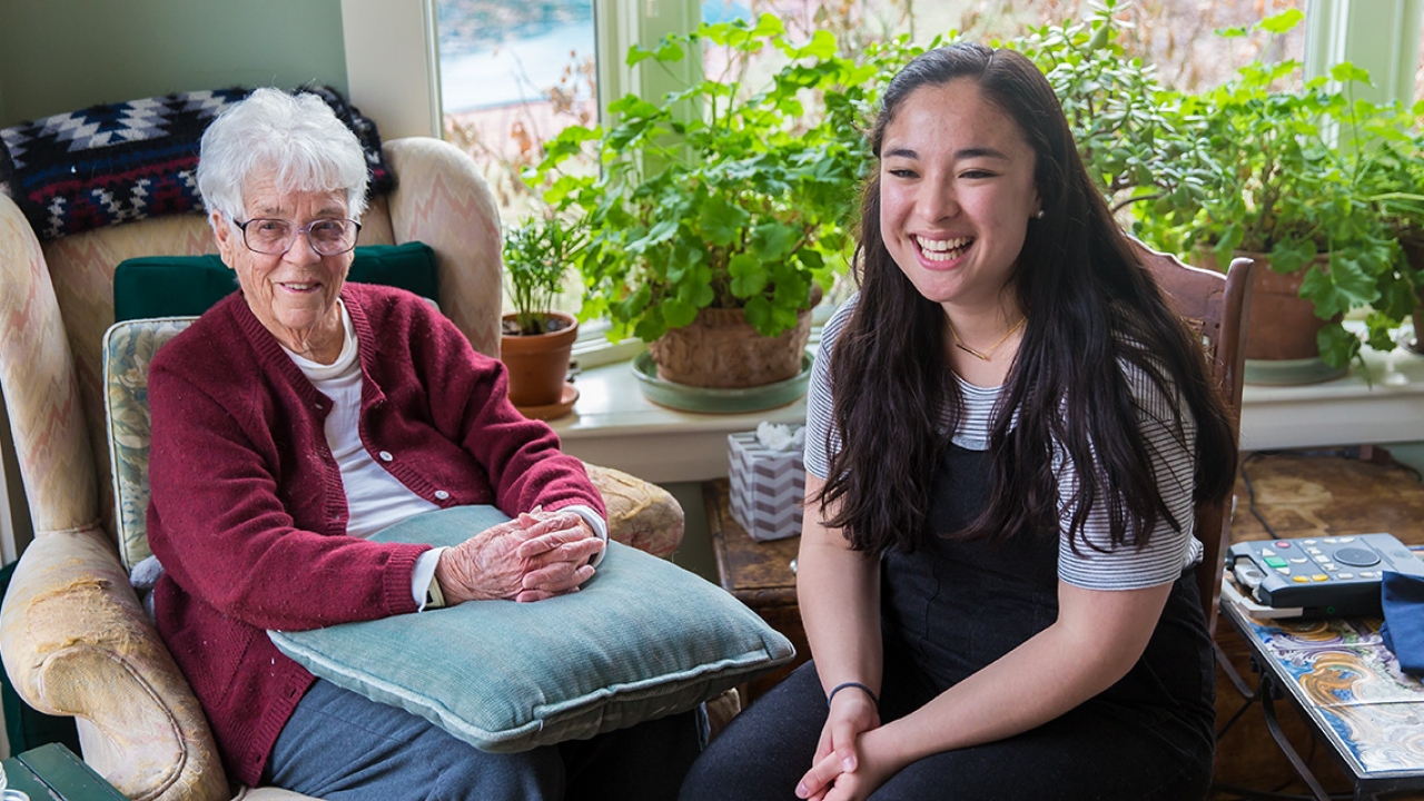 Kitty Gladstone sits with Wellesley student Margaret Calmer ’18 in her home.