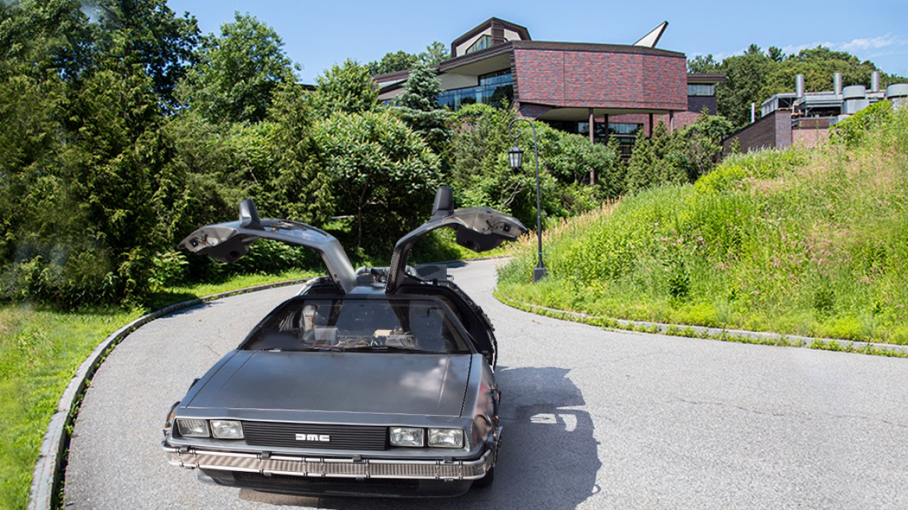 A DeLorean with doors up parked outside of LuLu Campus Center.