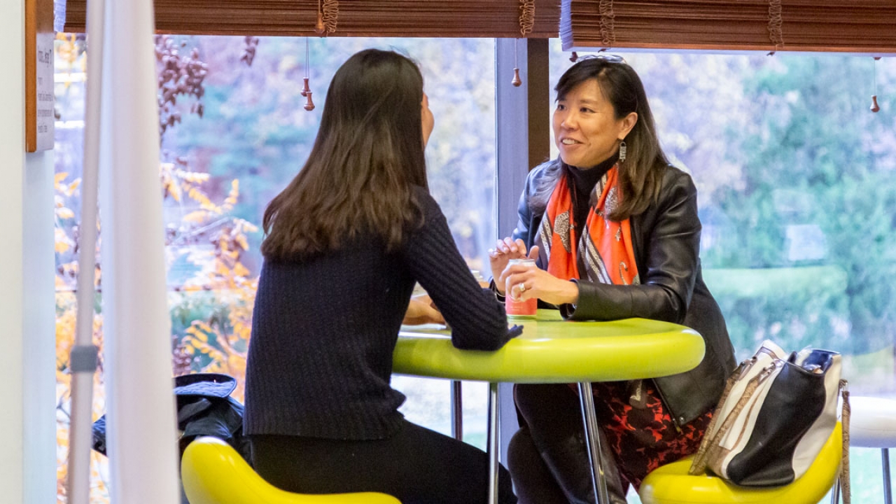 Alumna Staphanie Hsieh sits with a student in Lulu Campus Center 