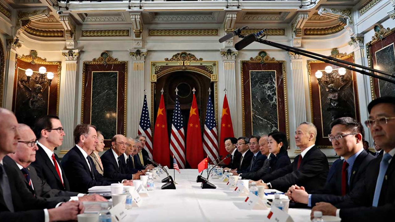 Diplomats sit around a large table. 
