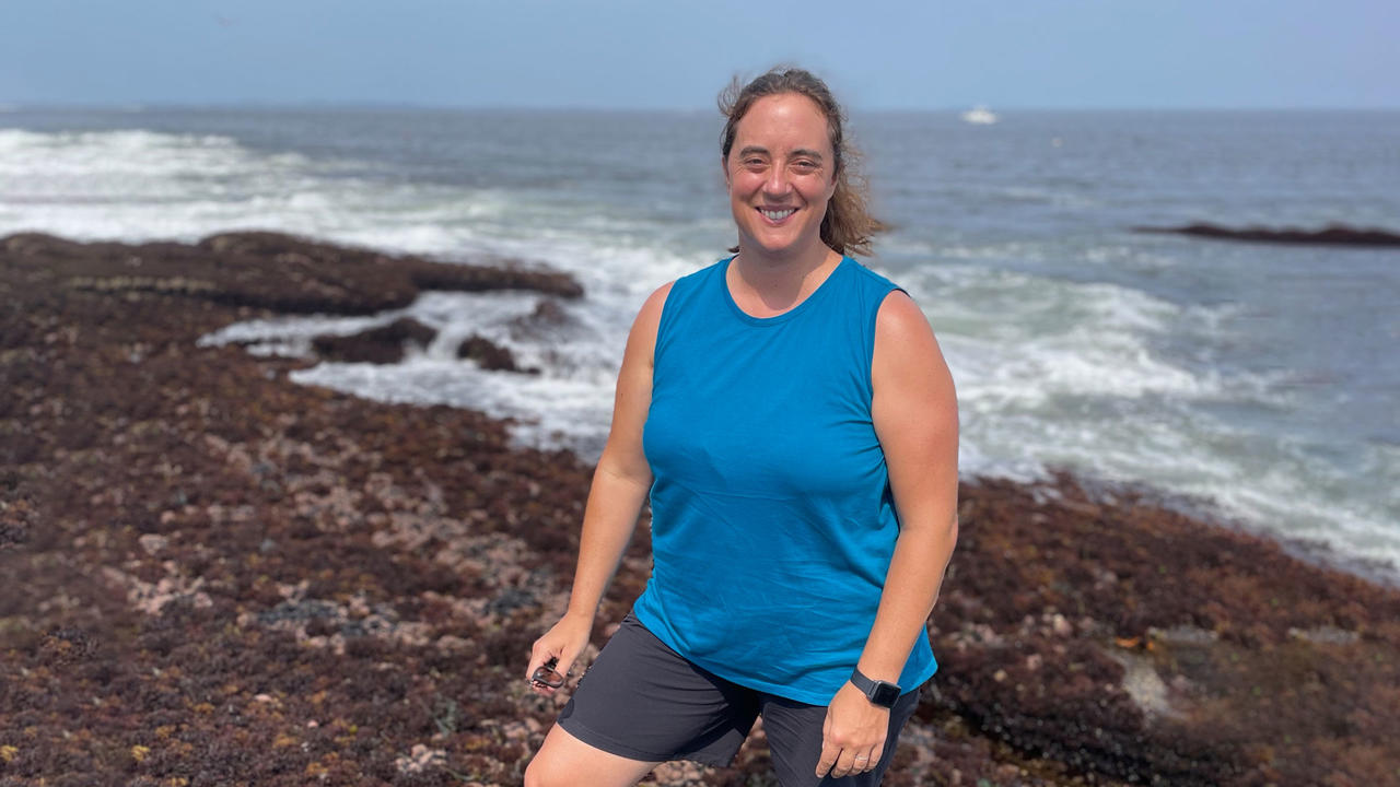 Rebecca Selden standing on a beach with the ocean behind her