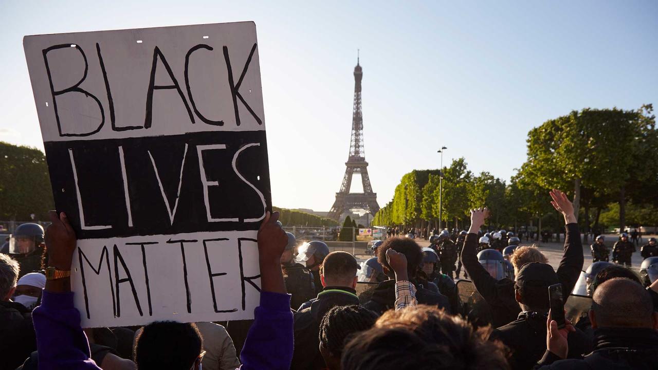 Black Lives Matter sign being held up in front of the Eiffel Tower