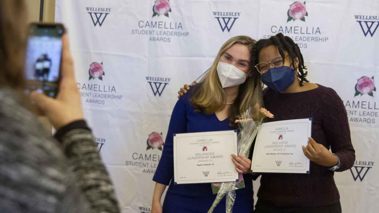 Junior Regina Gallardo and sophomore Alana Mackey pose for photo in front of the Camellia Awards backdrop