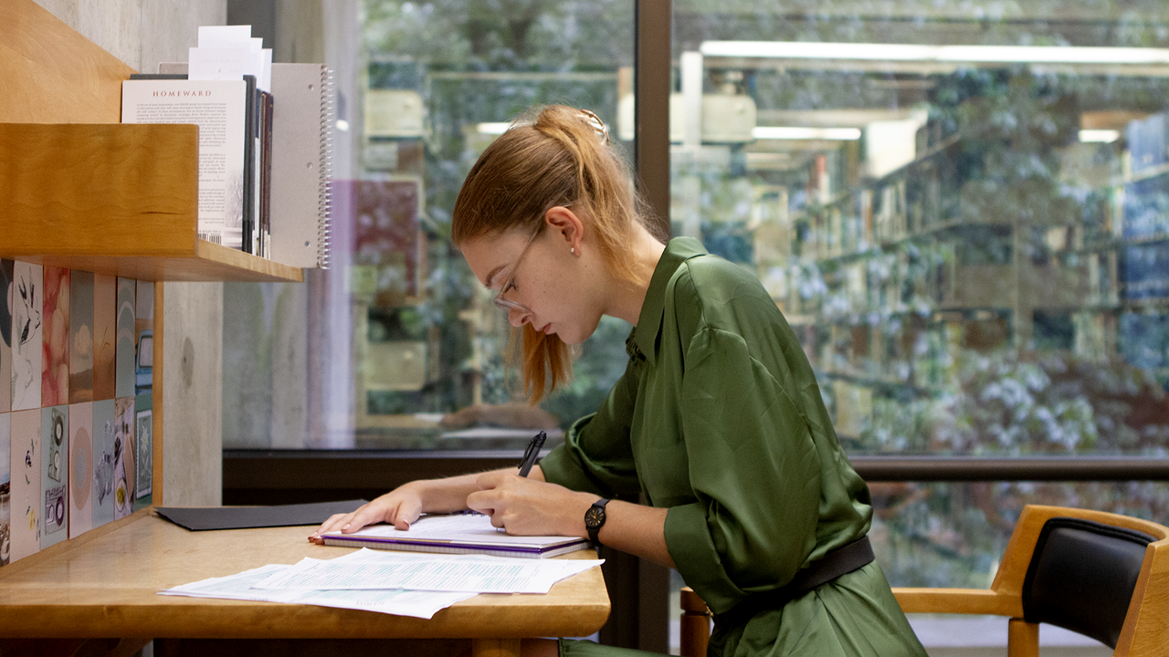 Clara Chambers ’24 studies at her thesis carrel in the library.