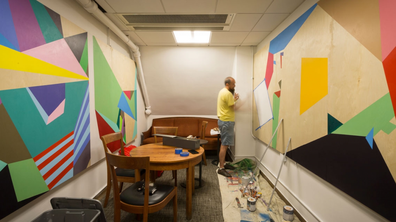 A Wellesley Professor paints a wall-sized mural.