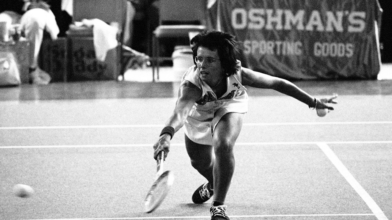 Billie Jean King bends down low to send the ball back over the net during the match with Bobby Riggs in the Astrodome