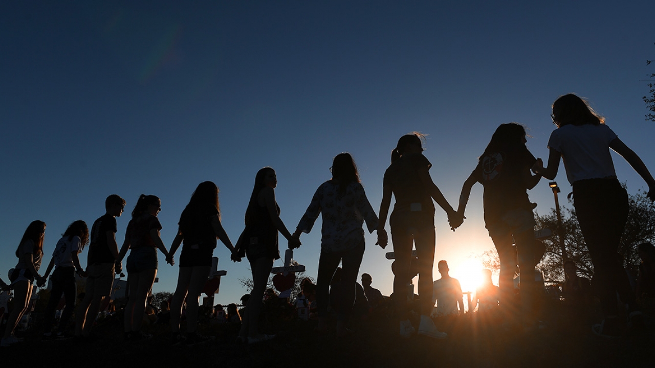 Students and their family members join hands outside Marjory Stoneman Douglas High School on February 18, 2018 in Parkland, FL.