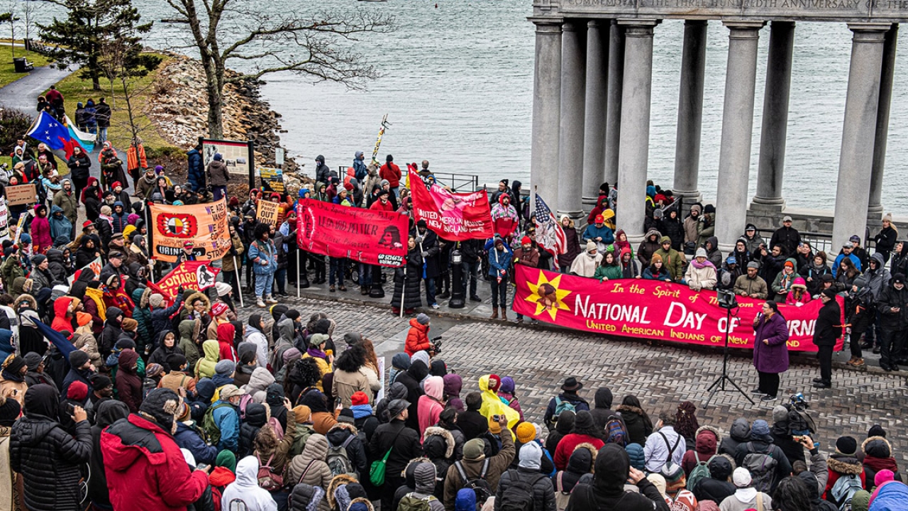 People attend a demonstration for National Day of Mourning along the water in Plymouth, MA.