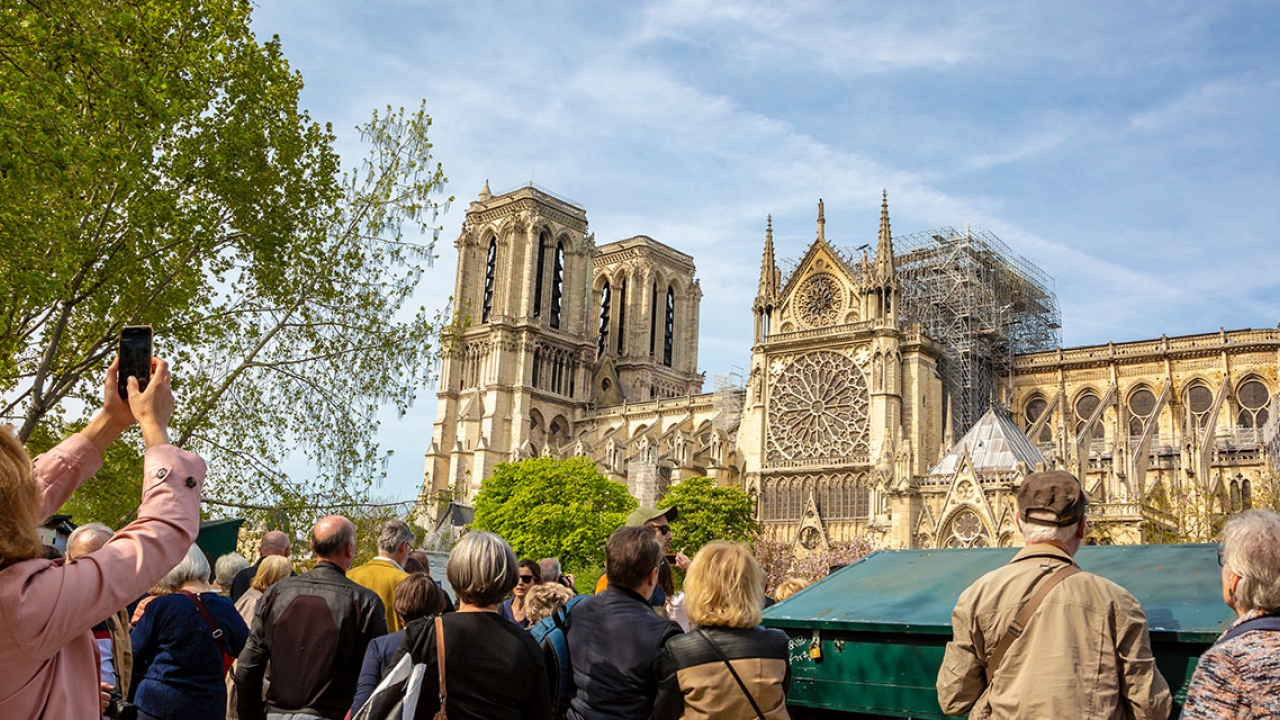 Tourists take photos of the Notre Dame cathedral after the April 2019 fire.