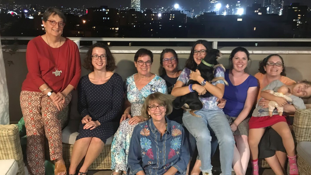 A group of Wellesley alumnae pose for a photo on a rooftop. 