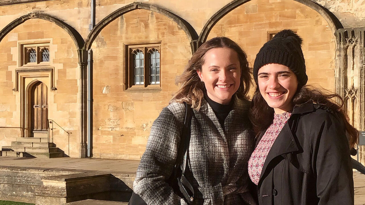 Two students stand outside a building in Oxford, England. 