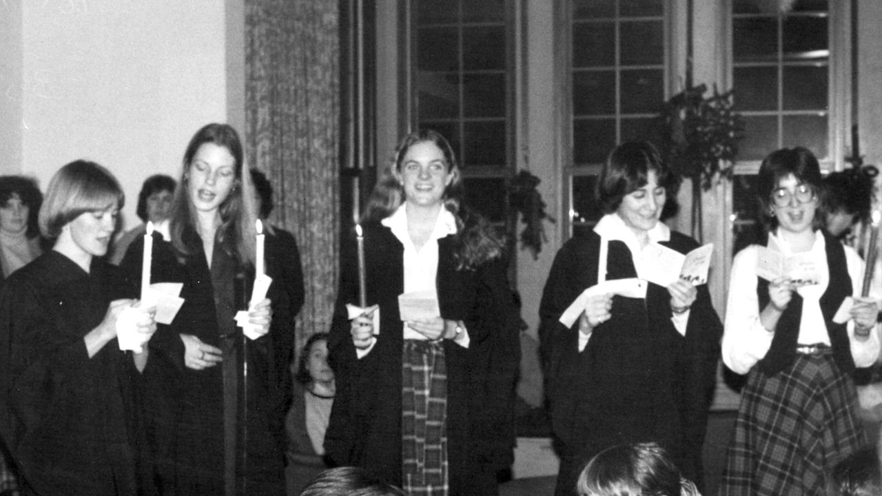 Vintage photo from 1980 showing students holding candles and singing for holidays.