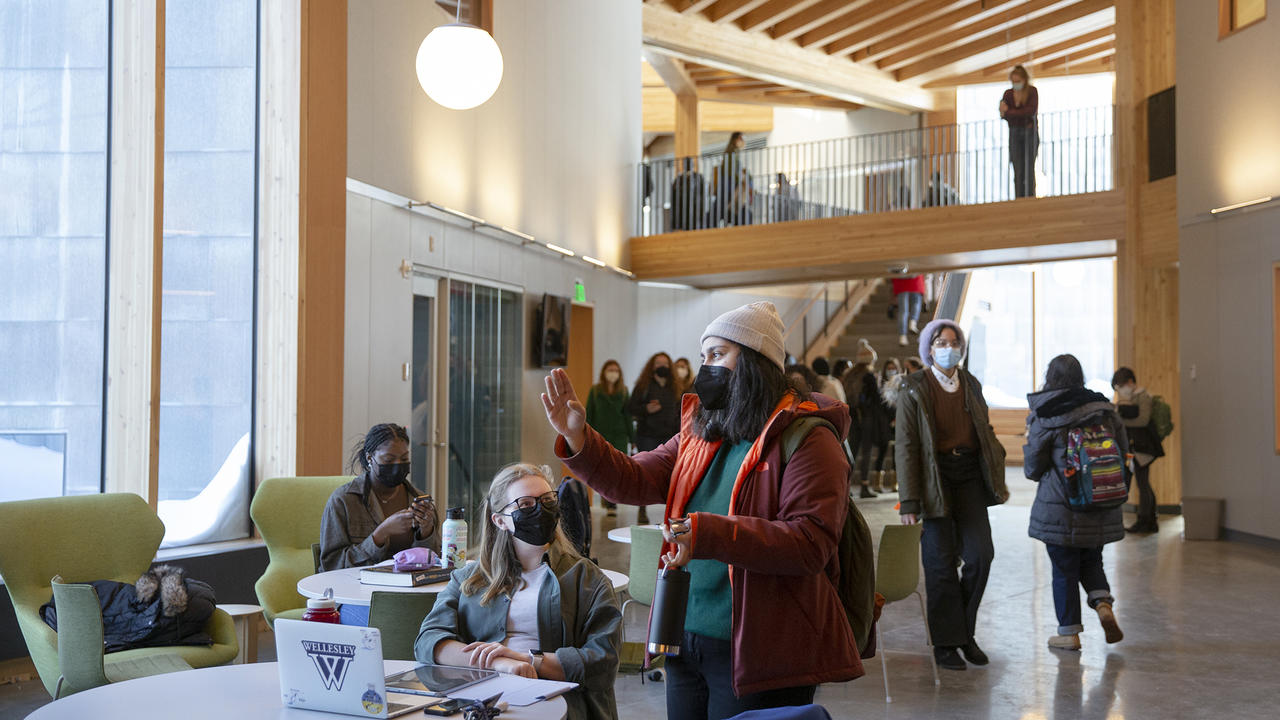 Two students talk to each others with other students walking by in the background in the new science center hub.