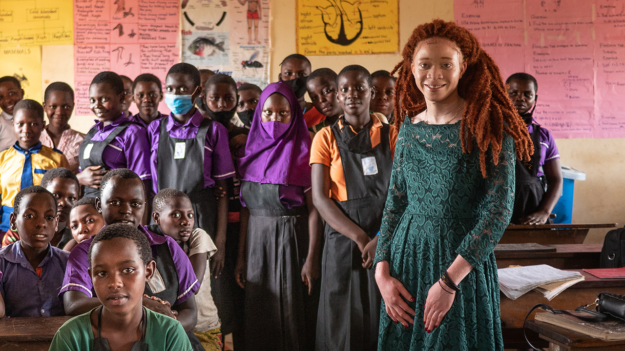 Chantale Zuzi '25 stands with a group of refugee girls at a resettlement camp in Uganda.