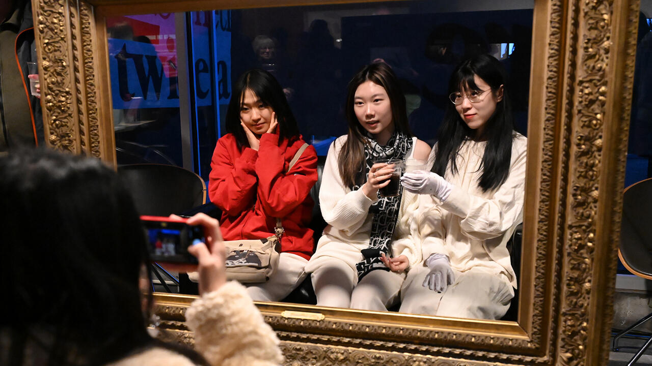 Three students pose for a photo within a gold frame.