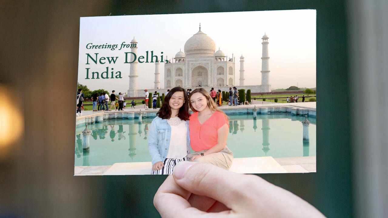 students smiling and standing in front of Taj Mahal