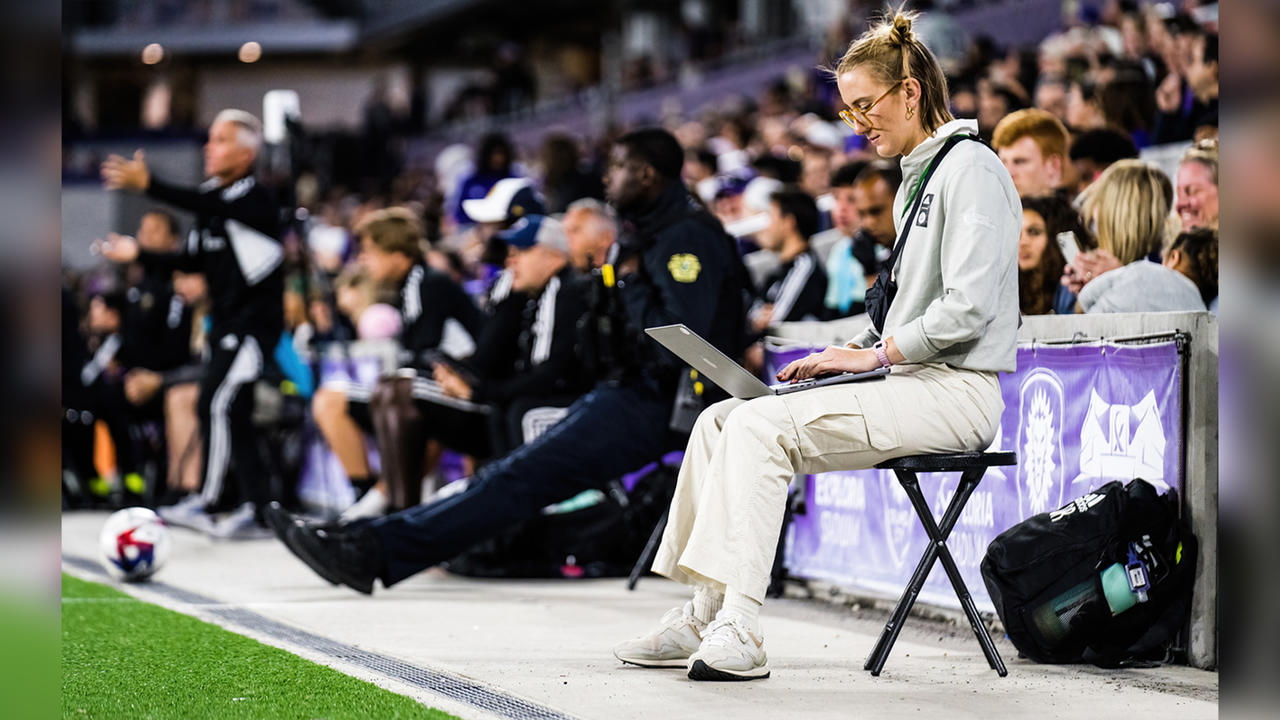 Olivia Reckley ’20 sits on the sidelines, working on her computer.