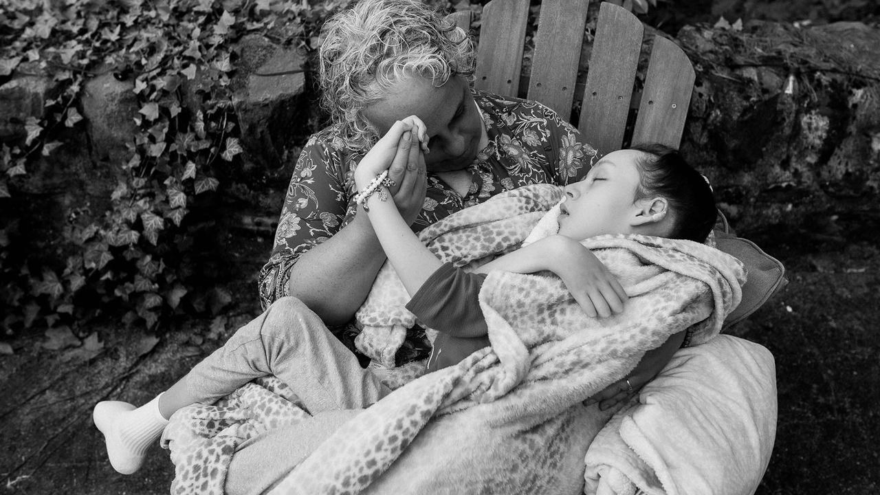 A photo of Maria Kefalas sitting in a chair with her daughter Cal on her lap.