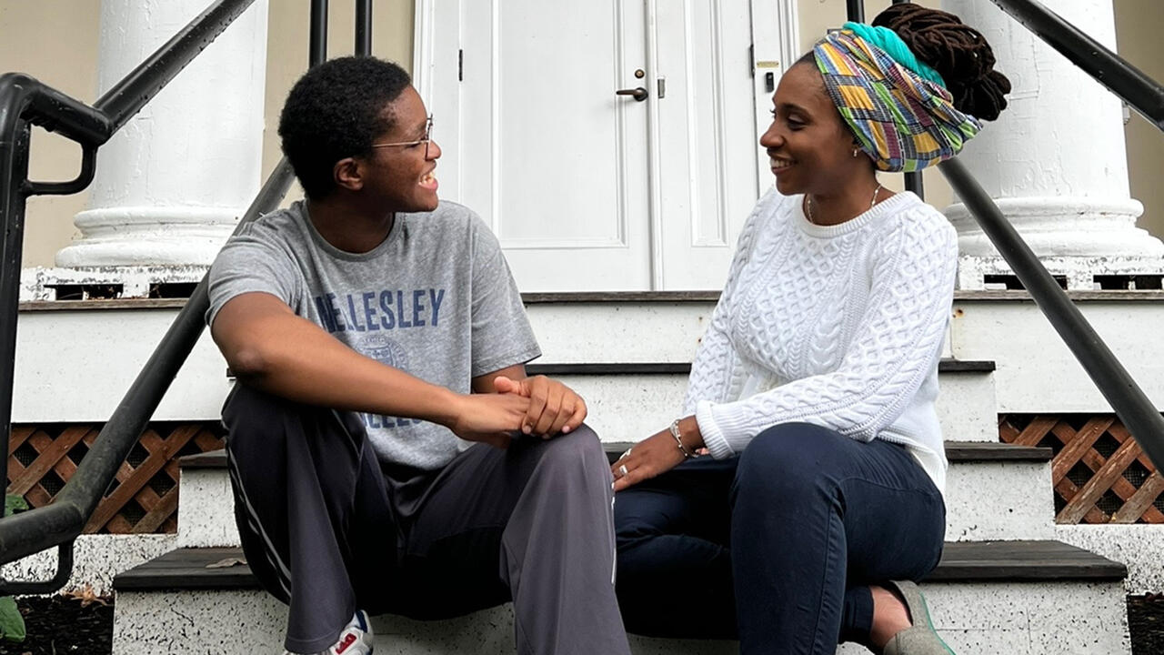 Izzy Torkornoo ’23 and Liseli Fitzpatrick speak to each other while sitting on the stairs of Harambee House.