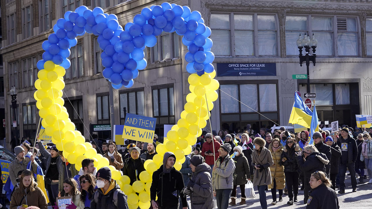 Demonstrators display a heart made of balloons featuring colors from the Ukrainian flag as they march during a rally in support 