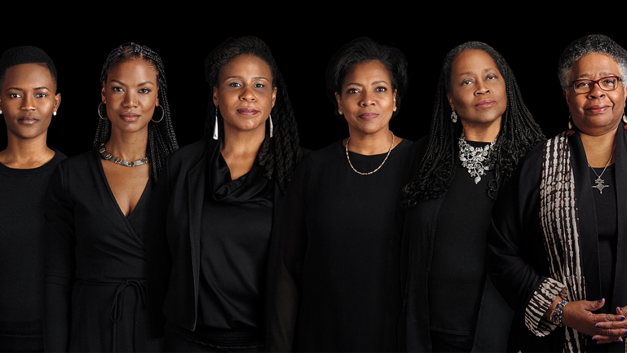 Six leaders of Ethos at Wellesley wearing black stand against a black backdrop looking directly at the camera.