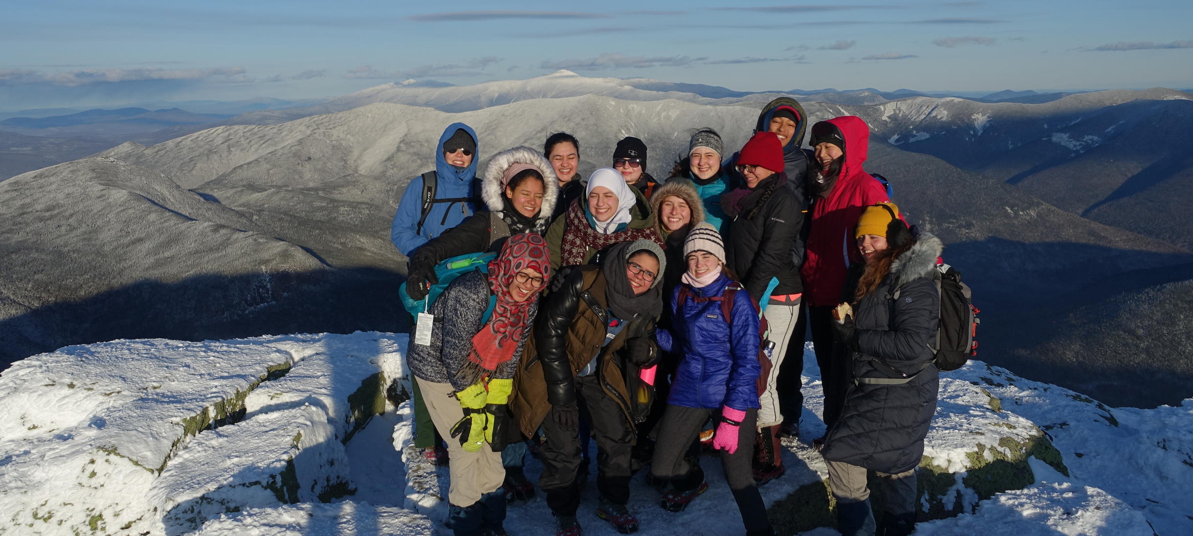 Group of students smiling on top of mountain