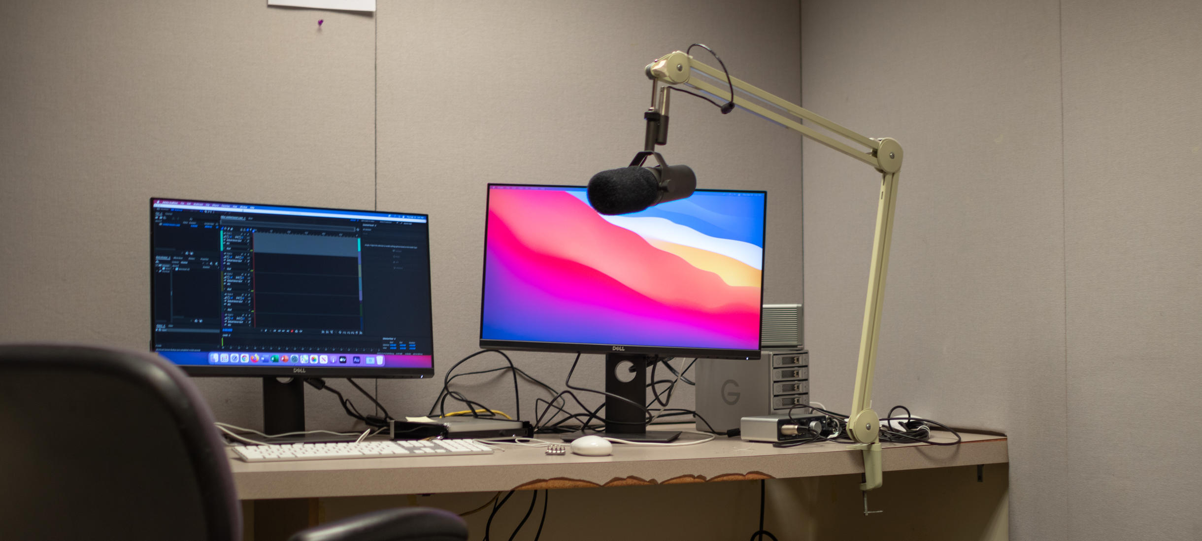 Two screens and one microphone boom arm for audio recording.