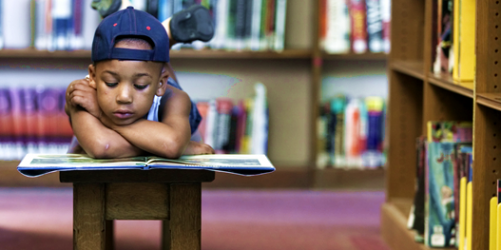 young boy reads a book 