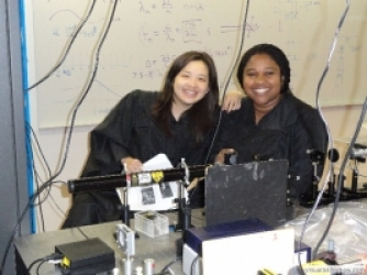 Lily Zhang '12 and Ijeoma Ekeh '12 with the open cavity helium neon laser.