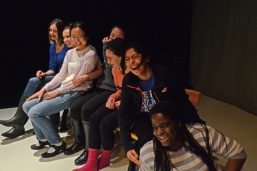 Seven students sitting and laughing.