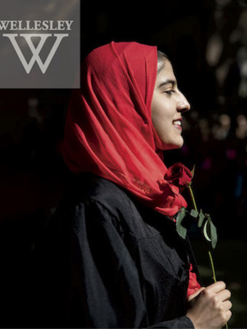Smiling student in profile holding red rose 