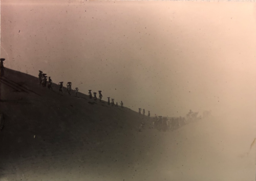 Sepia toned photo of railroad workers on a hill in India in the year 1899.